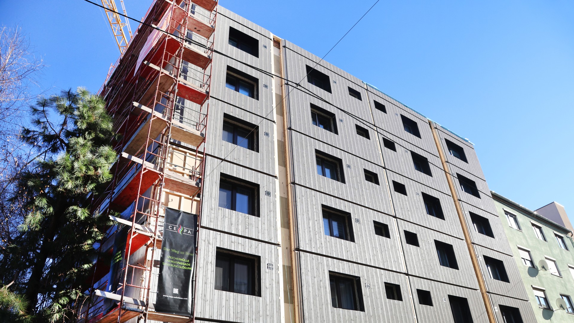 © Klimafonds / Krobath Ein mehrstöckiges Gebäude im Bau mit rotem Gerüst am linken Gebäuderand.