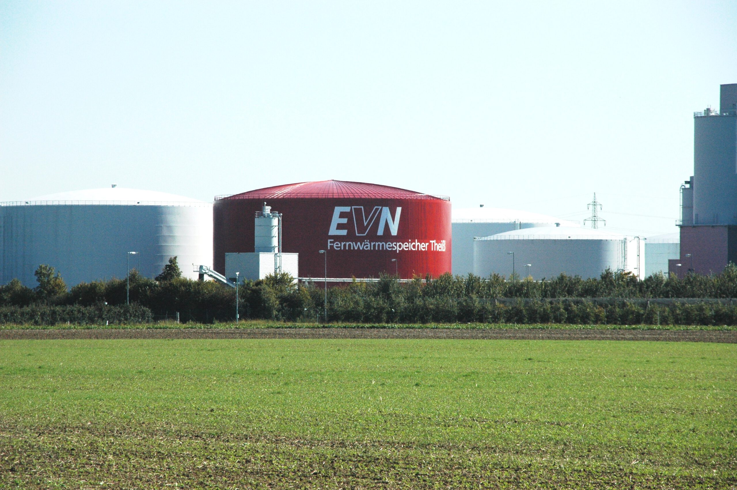 Roter Fernwärmespeicher mit Namen "Theiß" steht neben anderen Wärmespeichern