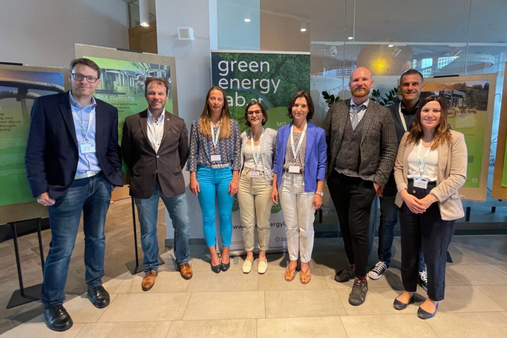 Acht Personen stehen vor Informationsplakate und einem Roll-up von Green Energy Lab