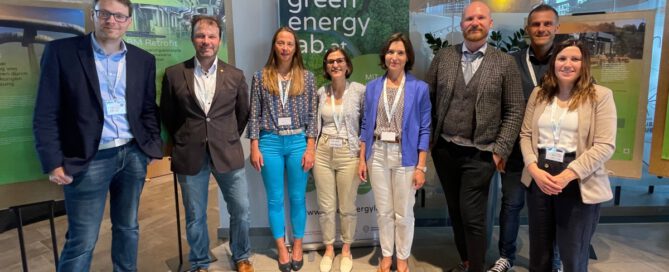 Acht Personen stehen vor Informationsplakate und einem Roll-up von Green Energy Lab
