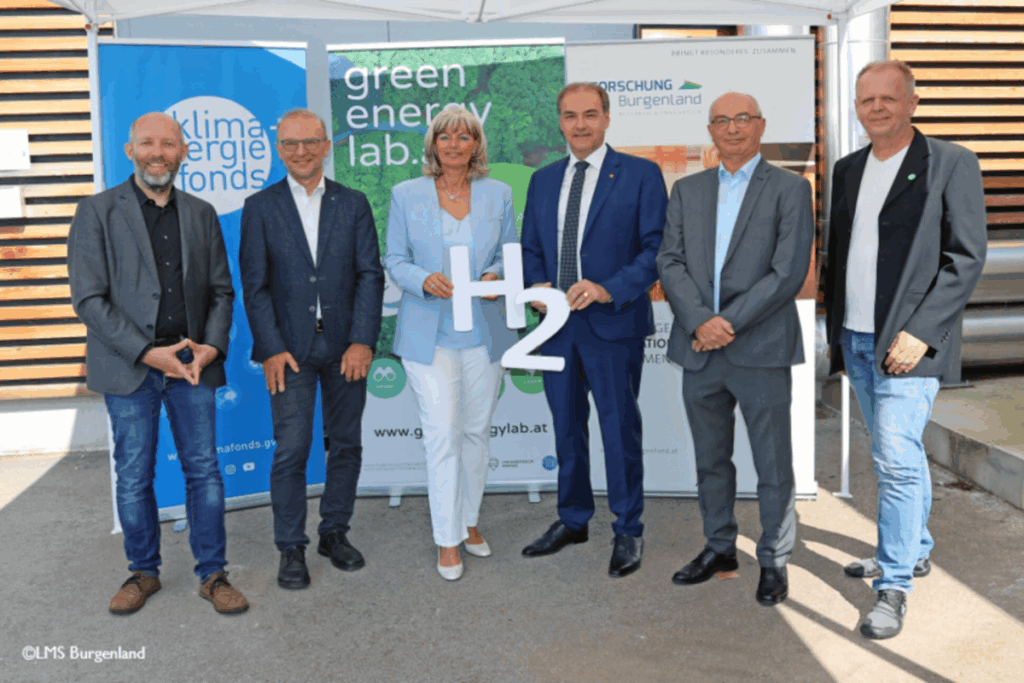 Sechs Personen stehen vor drei Roll-ups mit der Aufschrift, Klima- & Energiefonds, Green Energy Lab und Forschung Burgenland. Zwei Personen halten jeweils H und eine 2 in weiß in der Hand.