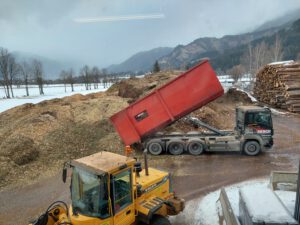 Lastwagen liefern Hackschnitzel an