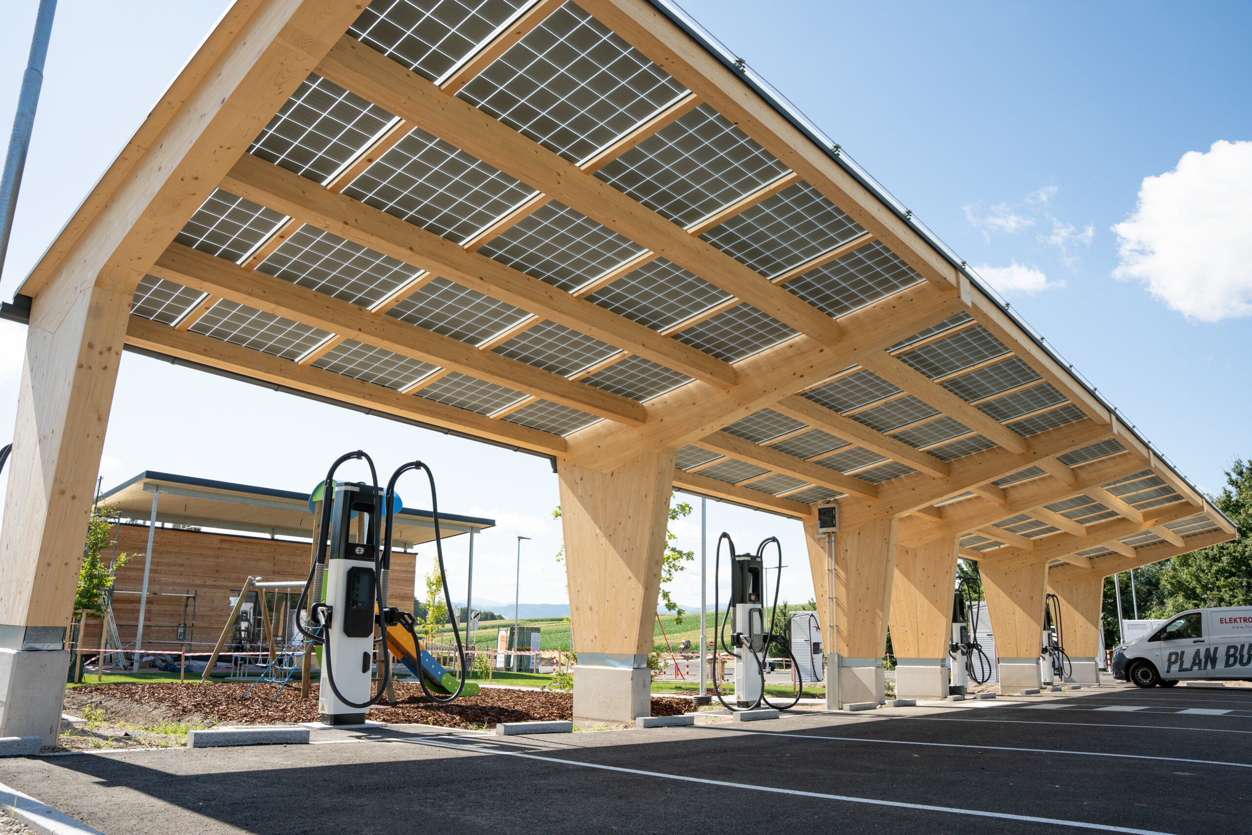 Ein mit PV-Modulen überdachter Carport mit Ladesäulen für Elektrofahrzeuge