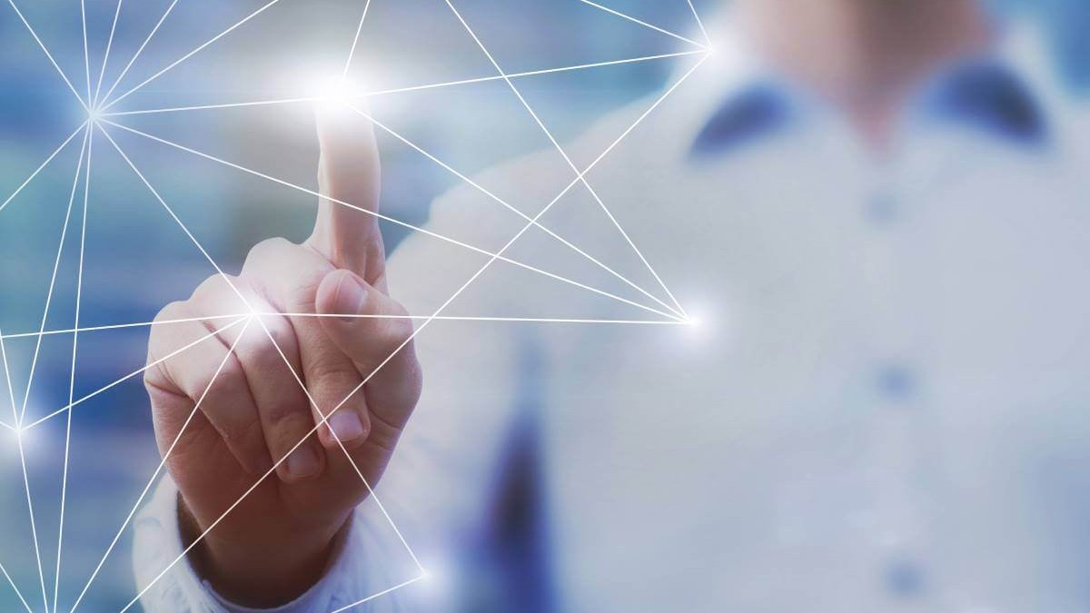 © iStock.com/anyaberkut Eine Person zeigt mit einem Finger auf ein Netzwerk aus weißen Linien