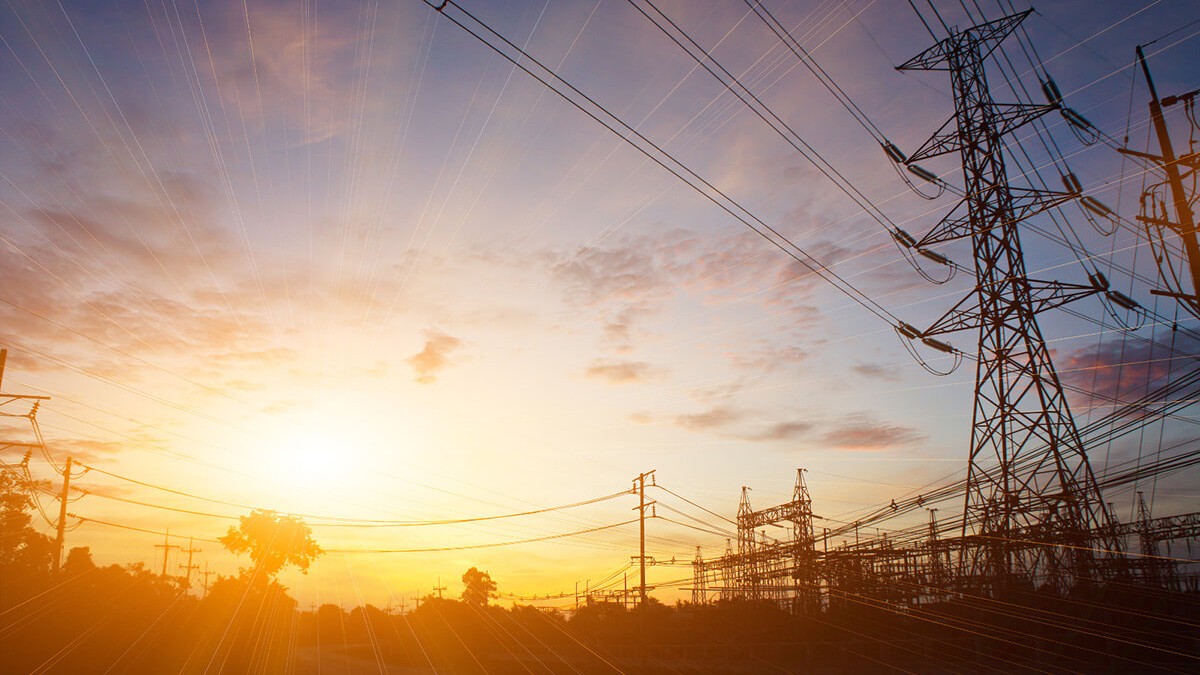 © iStock.com/jaochainoi Hochspannungsmasten bei Sonnenuntergang