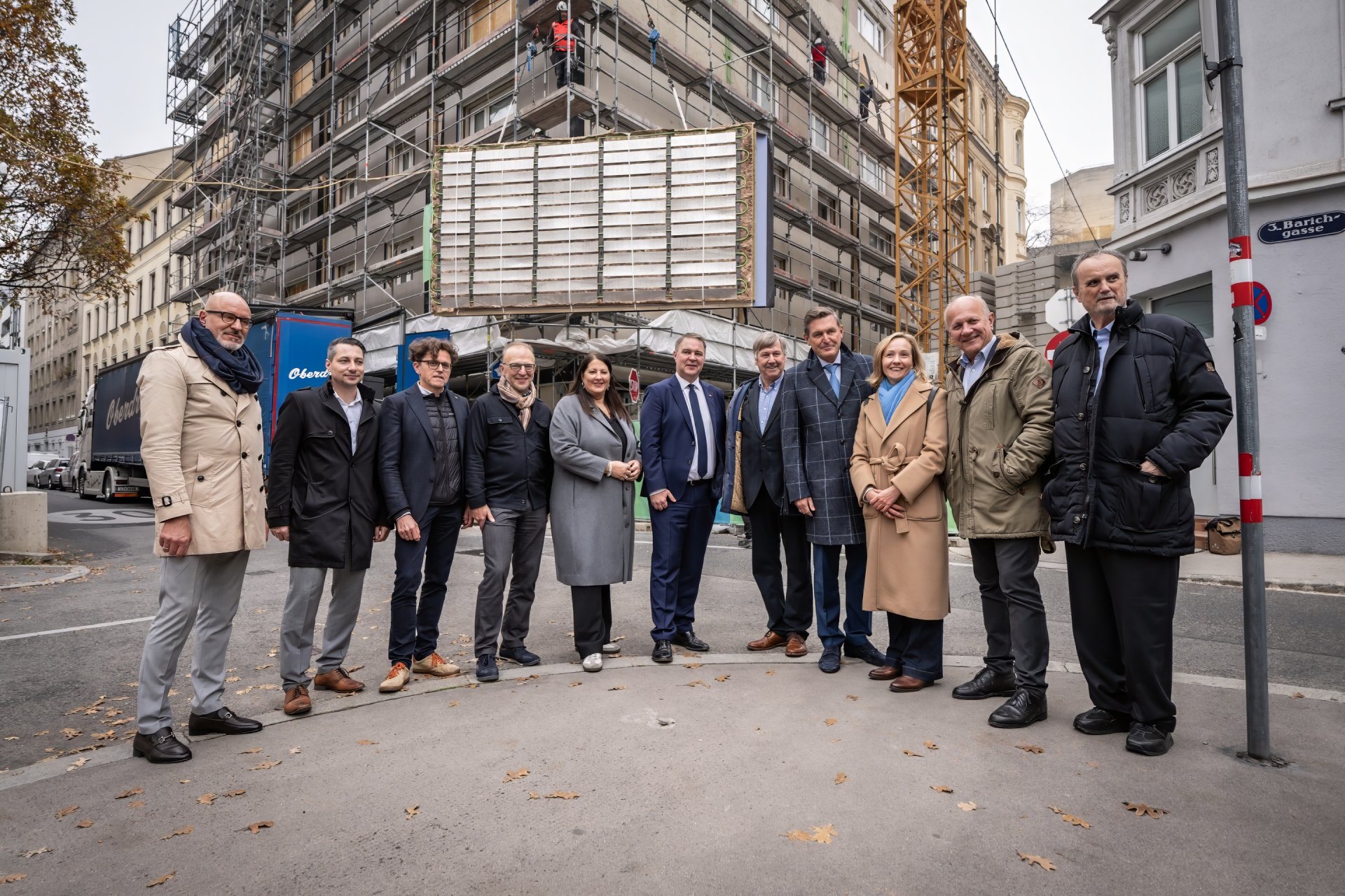 Elf Personen stehen vor einem Gebäude, das gerade saniert wird